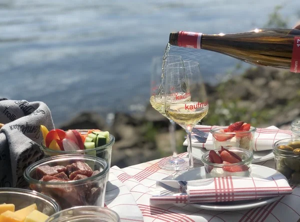 Picknick mit Wein, Käse und Erdbeeren am Rhein